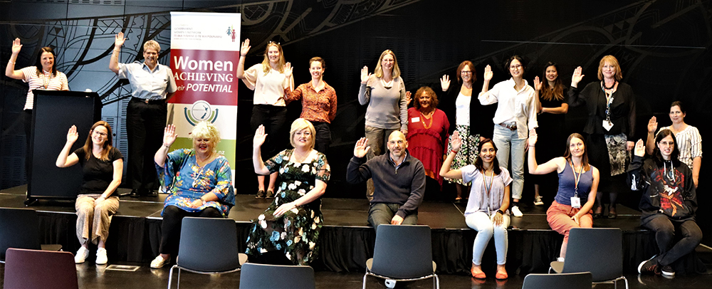 Event attendees adopt the 'Choose to Challenge' theme pose for International Women's Day 2021