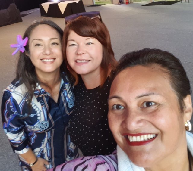 Three event attendees pose for a selfie