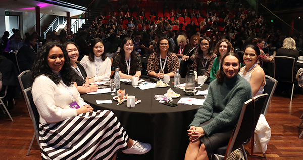 Elsa and other WIPS grantees at a table in the main session room