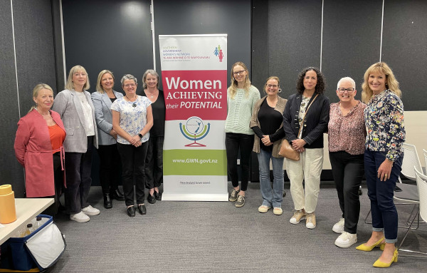 Speakers and committee members pose in front of SGWN banner